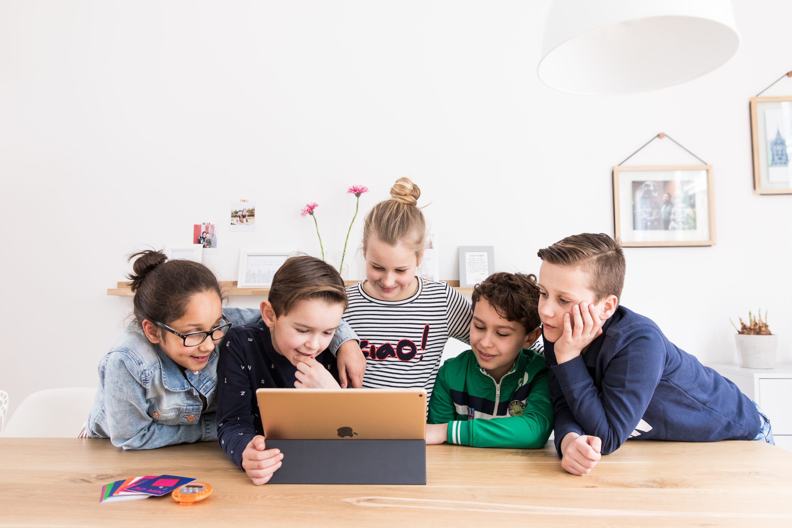 Four children around a tablet with Mytimingcards on the table