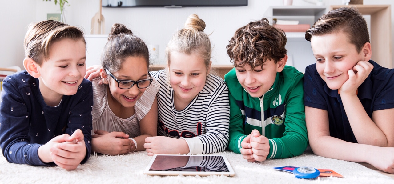 Five children looking at a tablet together